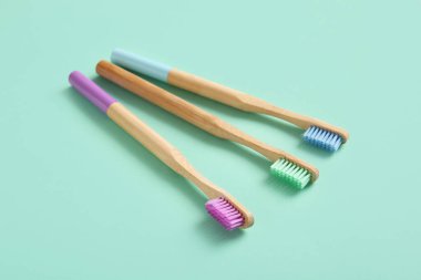 Turkuaz arka planda ahşap diş fırçaları olan kompozisyon, yakın plan.