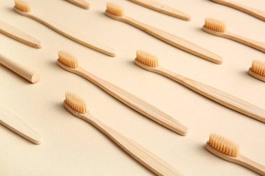 Bej arka planda ahşap diş fırçaları olan kompozisyon, yakın plan.