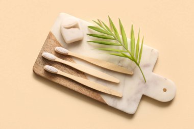 Tepsi ve bej arka planda ahşap diş fırçaları ile kompozisyon, yakın plan