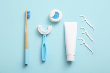 Mavi arka planda diş fırçası, diş ipi ve kürdan kompozisyonu, yakın plan