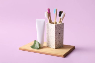 Tepsi, diş macunu ve arkaplanda ahşap diş fırçası olan cam.