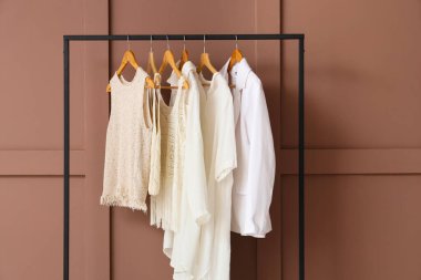 Kahverengi duvarın yanında şık kıyafetlerle dizilin, yakın plan.