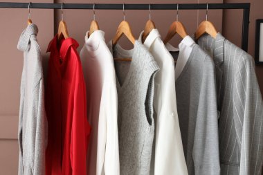 Kahverengi arka planda asılı giysilerle dizilin, yakın plan