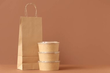 Kahverengi arka planda konteynırlar olan kağıt torba.