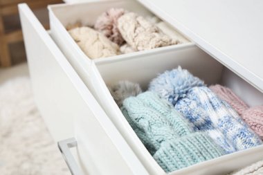 Dolapta organize kış kıyafetleri olan açık çekmece, yakın plan.