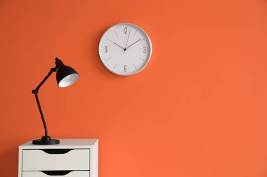 Dolapta turuncu duvarın yanında parlayan lamba