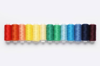 Beyaz arkaplanda farklı iplik makaraları kümesi