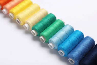 Beyaz arkaplanda farklı iplik makaraları kümesi, yakın plan