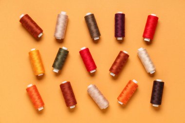 Turuncu arka planda birçok farklı iplik makarası