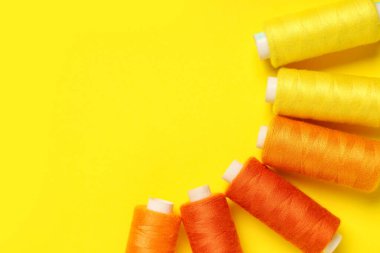 Sarı arkaplanda farklı iplik makaraları