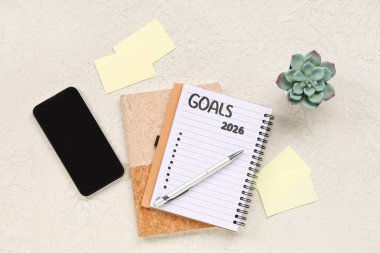 2026 gollü defter, cep telefonu ve beyaz grunge arkaplanı üzerine kağıt notlar