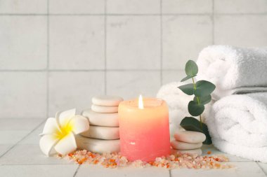 Fayans zemininde deniz tuzu, mum, havlu ve spa taşlarıyla kaplıca bileşimi