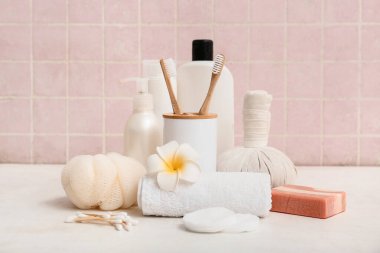 Kozmetik ürünler, çiçekler ve farklı banyo malzemeleri.