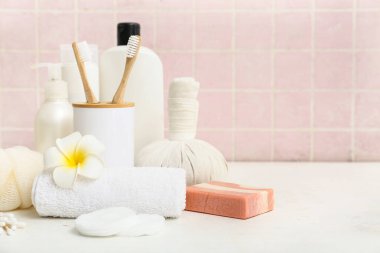 Kozmetik ürünler, çiçekler ve farklı banyo malzemeleri.