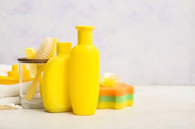 Bebek kozmetik ürünleri, banyo süngeri, taraklı cam ve ışık masasında saç fırçası.