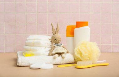 Tavşan oyuncağı ve bej masadaki çocuklar için farklı banyo aksesuarları