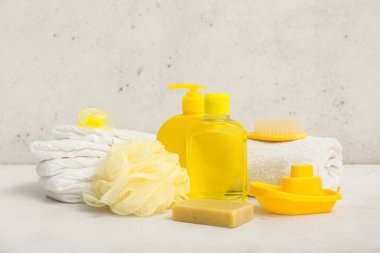 Tekne oyuncağı, emzik, bebek bezi ve arka plandaki çocuklar için farklı banyo aksesuarları.