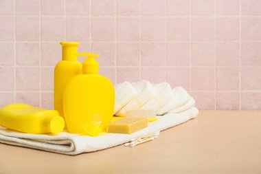 Bej masadaki bebek bezi ve farklı banyo aksesuarları.