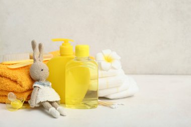 Tavşan oyuncağı, emzik, bebek bezi ve banyo aksesuarları.