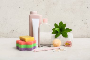 Bebek için emzik, yeşil dal ve farklı banyo aksesuarları.