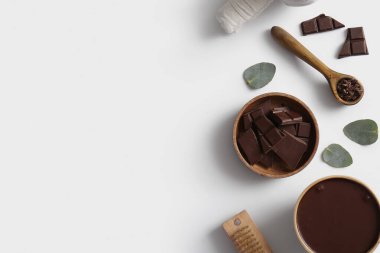 Çikolata parçalı spa kompozisyonu ve beyaz arka planda erimiş çikolata.