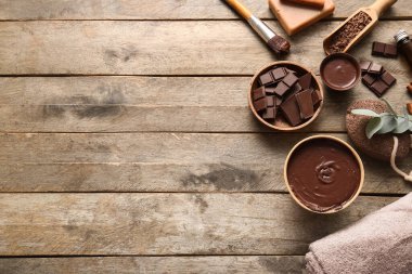 Erimiş çikolata, sünger taşı ve ahşap zemin üzerinde makyaj fırçası olan spa kompozisyonu