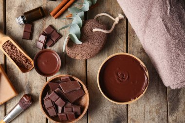 Erimiş çikolata, sünger taşı ve ahşap zemin üzerinde makyaj fırçası olan spa kompozisyonu