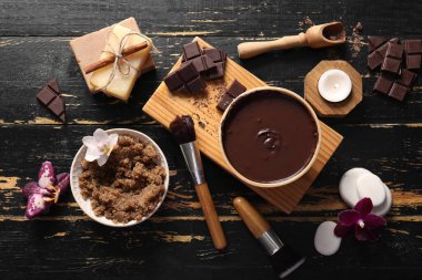 Tepsisi, erimiş çikolatası ve siyah ahşap arka planda deniz tuzu olan güzel bir spa kompozisyonu.