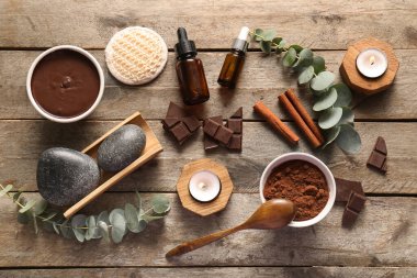Kakao tozu dolu spa kompozisyonu ve ahşap zemin üzerinde erimiş çikolata.
