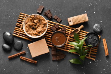 Bambu tepsisi, erimiş çikolata ve siyah zemin üzerinde deniz tuzu olan güzel bir spa kompozisyonu.