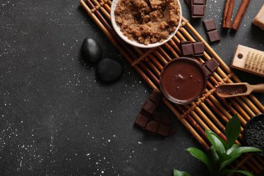 Bambu tepsisi, erimiş çikolata ve siyah zemin üzerinde deniz tuzu olan güzel bir spa kompozisyonu.