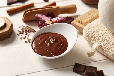 Beyaz ahşap arka planda erimiş çikolatalı spa kompozisyonu, yakın plan.