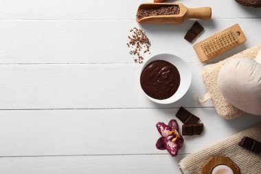 Güzel bir spa kompozisyonu, erimiş çikolata, ahşap kepçe ve beyaz ahşap arka planda çiçek.