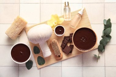 Arkaplanda erimiş çikolata ve kozmetik ürünleri olan spa kompozisyonu