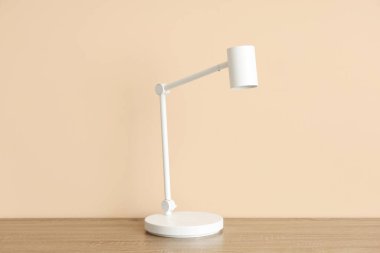 Masa lambası bej duvarın yanındaki odada.