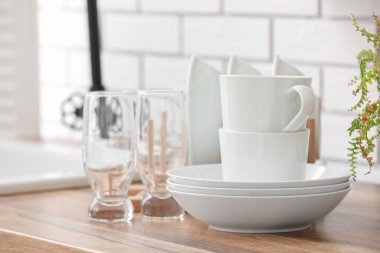 Mutfaktaki masada temiz sofra takımı var.