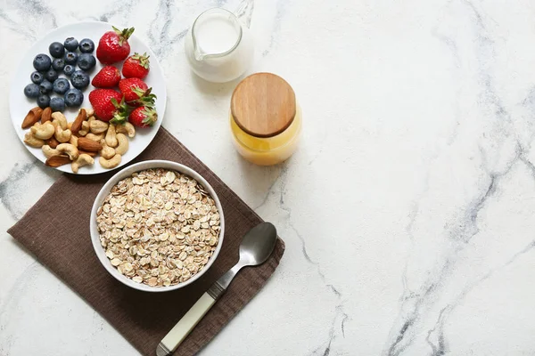 Peçete, fındık, böğürtlen ve mermer arka planda çiğ yulaf ezmesi