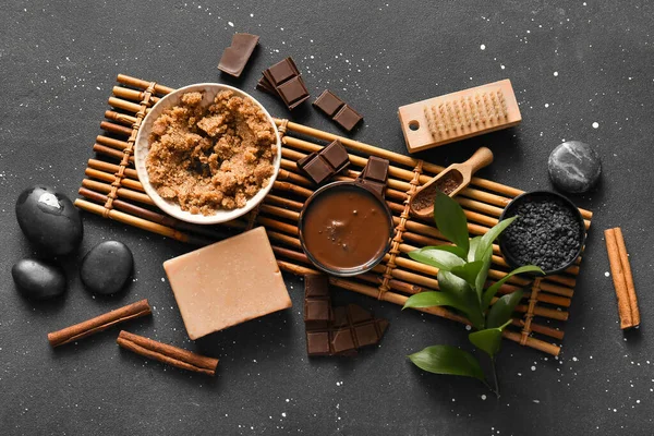 Bambu tepsisi, erimiş çikolata ve siyah zemin üzerinde deniz tuzu olan güzel bir spa kompozisyonu.
