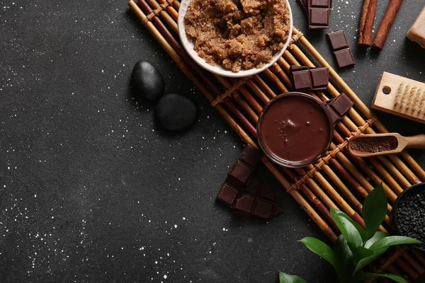 Bambu tepsisi, erimiş çikolata ve siyah zemin üzerinde deniz tuzu olan güzel bir spa kompozisyonu.