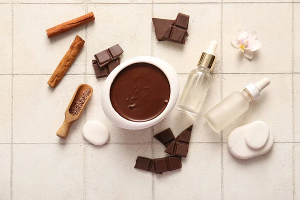 Fayans zemininde erimiş çikolata ve kozmetik ürünleri olan güzel bir spa kompozisyonu.