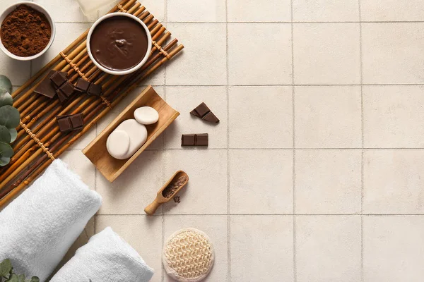 Bambu tepsisiyle güzel bir spa kompozisyonu, erimiş çikolata kaseleri ve fayans zemininde kakao tozu.