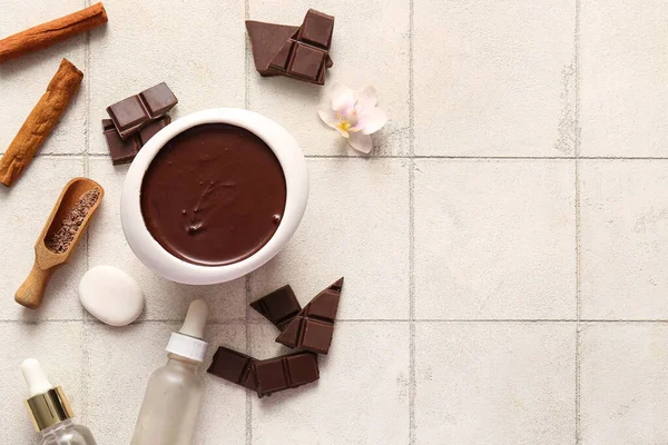 Fayans zemininde erimiş çikolata ve kozmetik ürünleri olan güzel bir spa kompozisyonu.