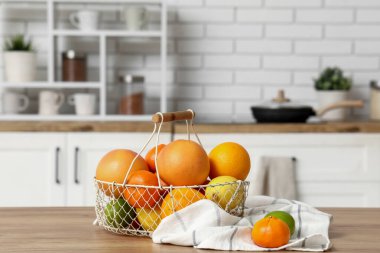 Mutfaktaki masada nefis narenciye meyveleri olan sepet.