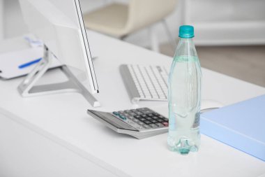 Ofisteki masada plastik su şişesi, yakın plan.