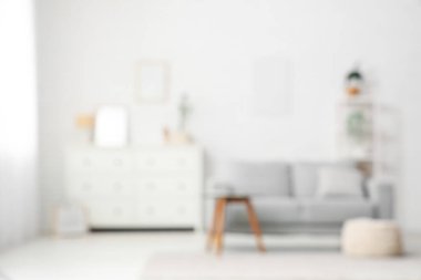 Kanepesi ve beyaz duvarı olan modern oturma odasının bulanık görüntüsü.