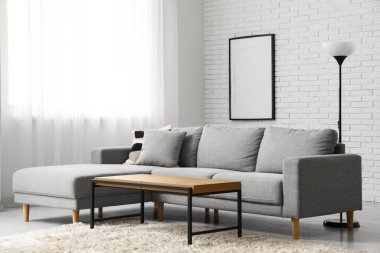 Oturma odasının penceresinin yanındaki masa ve kanepe.