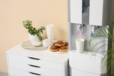 Modern su soğutucusu ve sandık bej duvarın yanında, yakın plan.