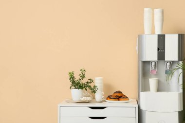 Modern su soğutucusu ve sandık bej duvarın yanında, yakın plan.