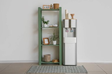 Modern su soğutucusu ve raf odası beyaz duvarın yanında.