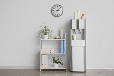 Modern su soğutucusu ve raf odası beyaz duvarın yanında.